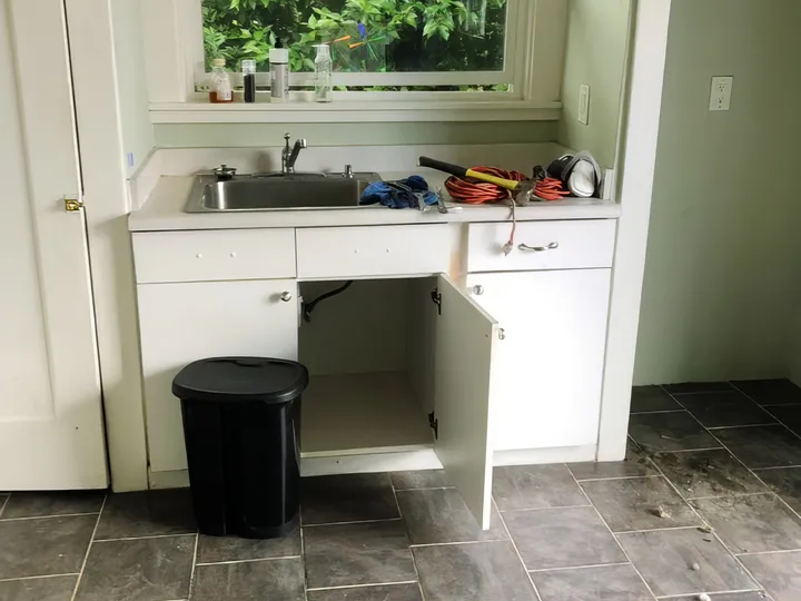 Kitchen before renovation showing old cabinets