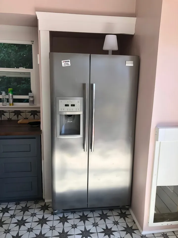 Kitchen after renovation with new cabinets, flooring, paint, and refrigerator