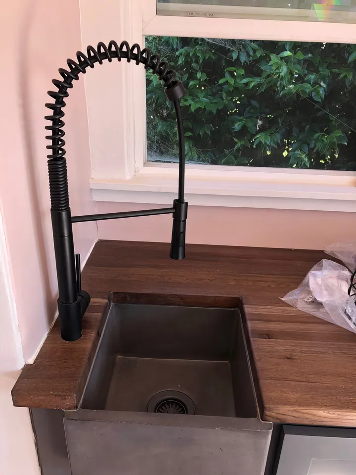 Kitchen after renovation with new faucet, sink, countertop, and paint